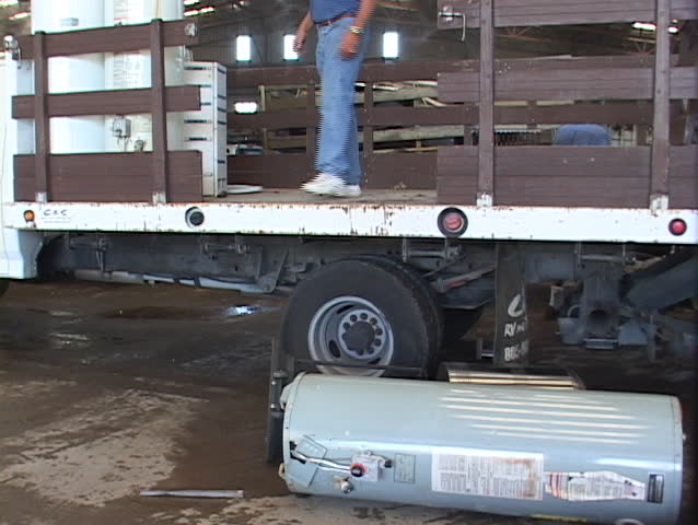 Workers unload scrap metal in a large recycling center.