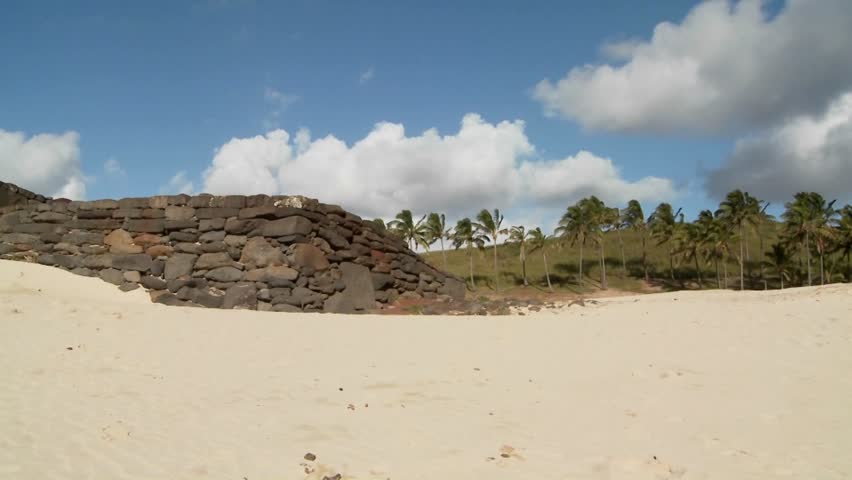 A pan across to Easter Island statues on a beach in the distance.