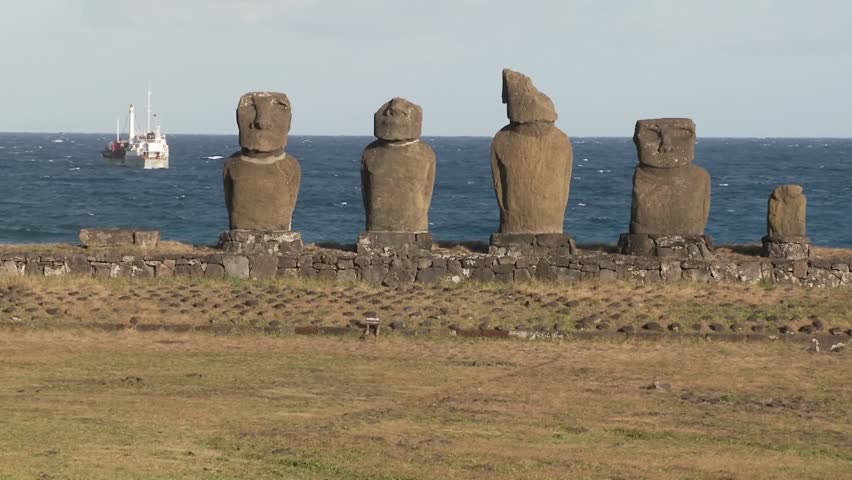 Broken statues on Easter Island with a boat.
