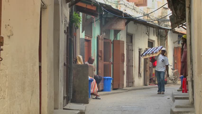 TANZANIA - CIRCA 2009: A sunglasses vendor walks on the streets of old Stone Town, Zanzibar circa 2009 in Tanzania.
