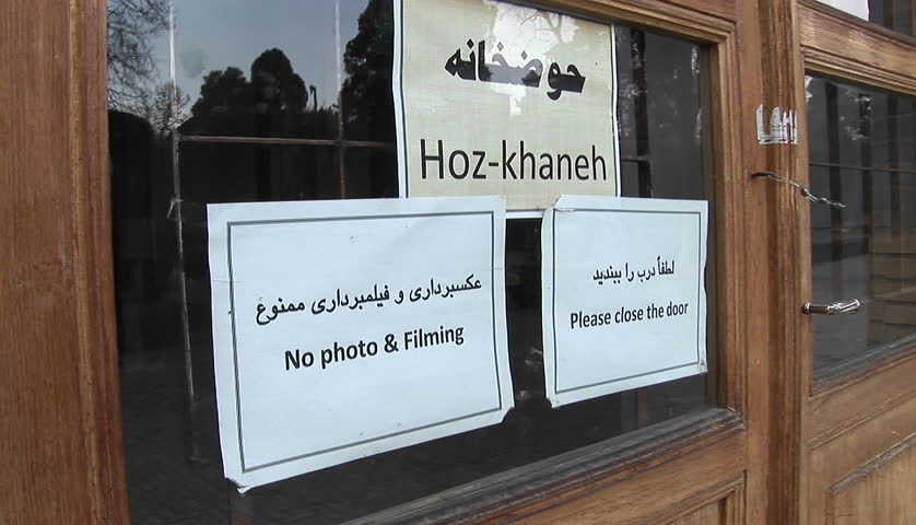 Signs on a window in Iran. Prohibits photography and ask visitors to close the door.