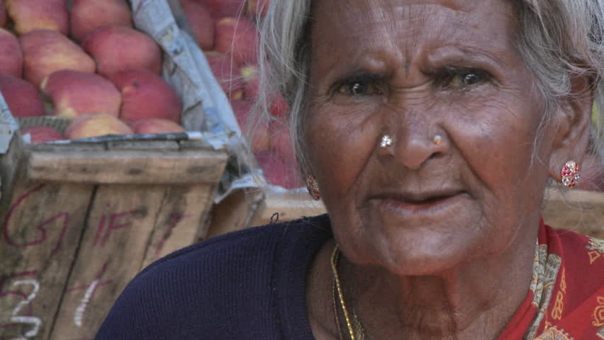 INDIA - CIRCA 2010: Elderly Asian woman having a conversation with someone circa 2010 in rural India. India contains the largest concentration of people living below the World Bank's international poverty line of US$1.25 per day.