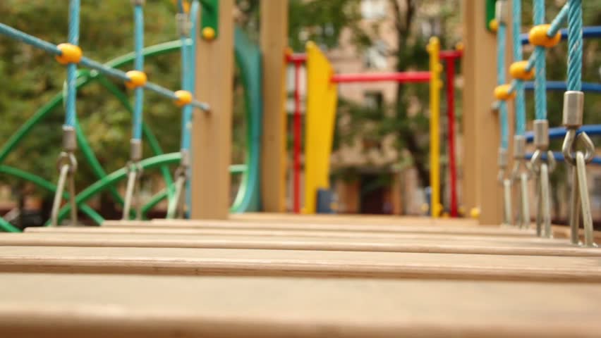 Little girl run on hang down wooden steps few times at playground