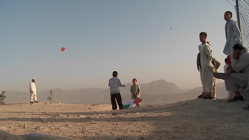 KABUL, AFGHANISTAN - CIRCA 2009: Kids chase and play with kites in an empty lot circa 2009 in Kabul, Afghanistan. Afghanistan is an impoverished and least developed country, one of the world's poorest. 