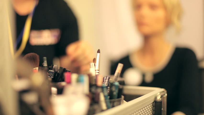 Professional makeup artist putting cosmetics.  Focus on the instrument.