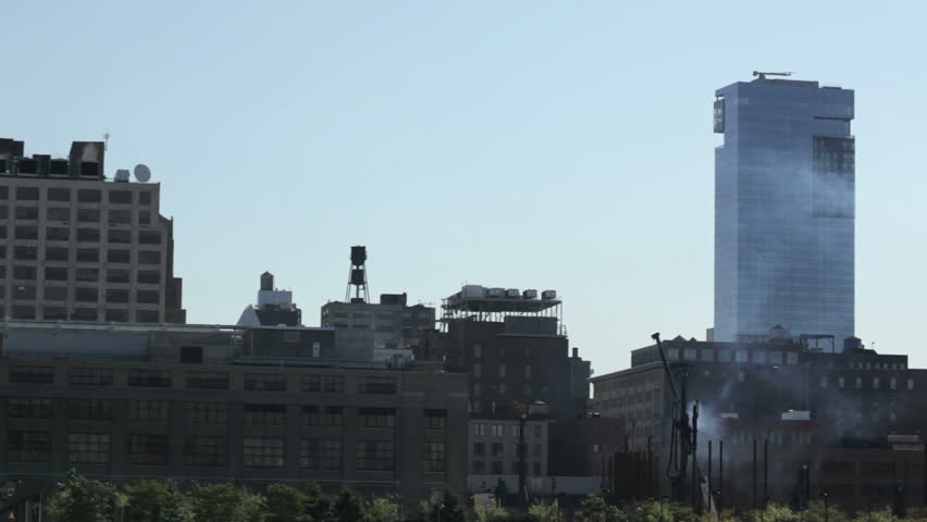 heavy machinery 'pile driving' foundations on the west side of Manhattan. filmed from a pier with the sound of waves and the noise of pile driving.