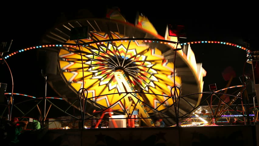 Colorful illuminated fun ride in amusement park at night