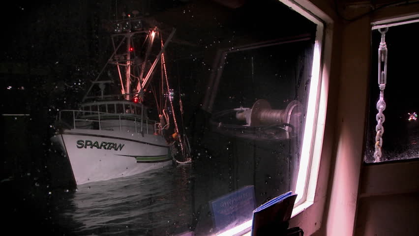NOME, ALASKA - CIRCA 2009: A boat bobs in the water, then begins to move, as seen through the window of another boat circa 2009 in Nome.