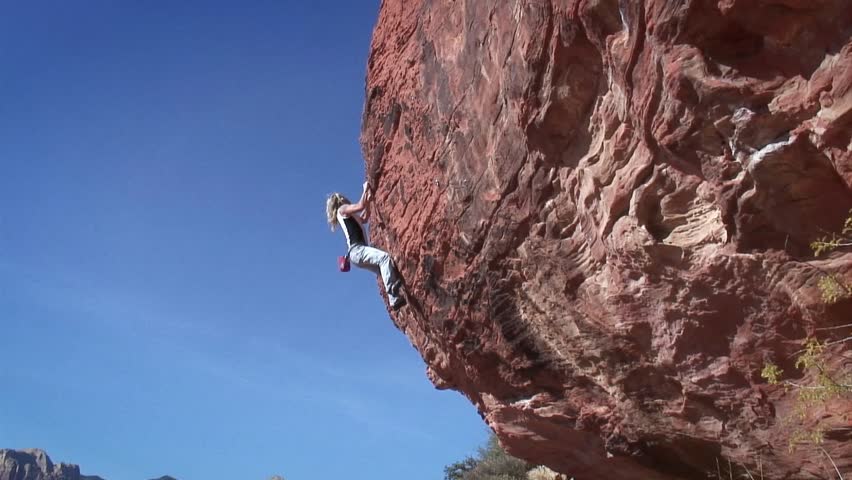 woman climbs the side of a mountain circa 2009 in Joshua Tree.