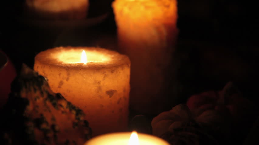 Candles burning in a dark room camera pivots the the left