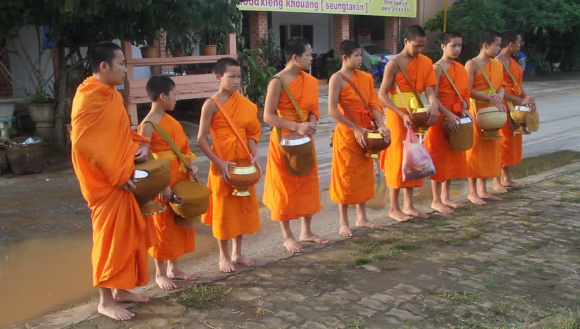 PHONSAVAN, LAOS - CIRCA SEPTEMBER 2011 - Women give food for the buddhist monks on the street circa September 2011. 67% of the population of Laos is Theravada Buddhist.