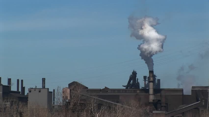 A small industrial plant spews out smoke.