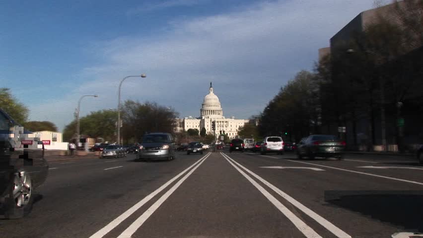 WASHINGTON, D.C. - CIRCA 2009: View tracks-in on the United States Capitol Building in the background of streets flowing with traffic.