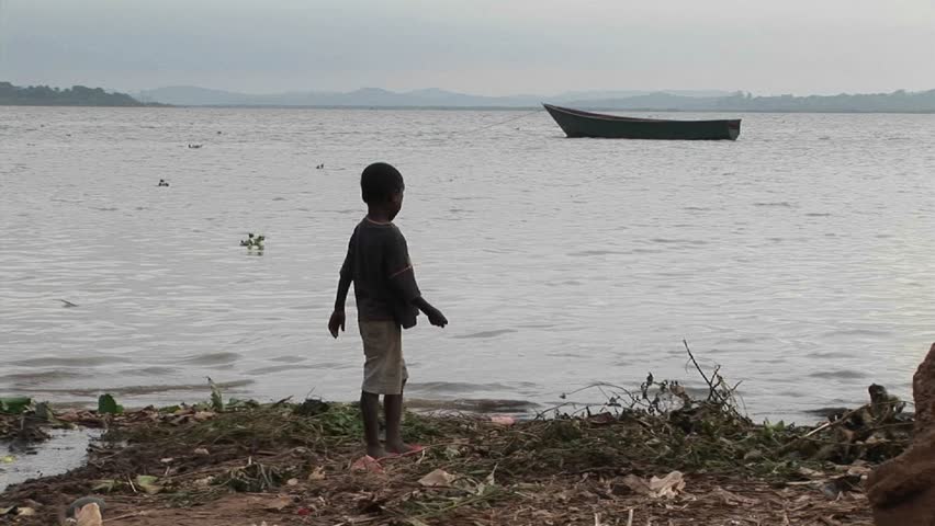 LAKE VICTORIA, UGANDA - CIRCA 2009: A young boy plays along shore circa 2009 in Lake Victoria.