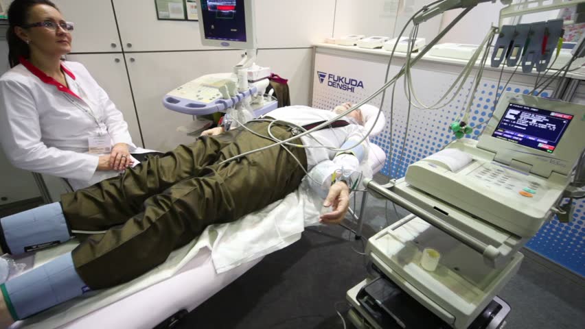 MOSCOW - DEC 8: Nurse sits near man lying at exhibition Zdravookhraneniye2010, 20th International Exhibition for Health Care, Medical Engineering and Pharmaceuticals, Dec 8, 2010, Moscow, Russia
