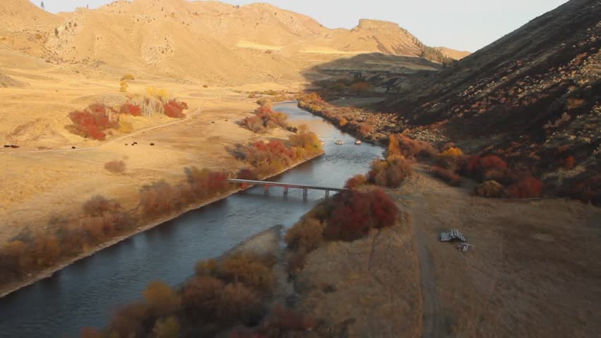 Aerial footage of flying a river canyon in Idaho with a ranch in view.