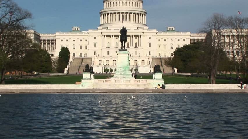 Panning up from the Reflecting Pool in Washington, DC and focusing on the U.S. Capitol building.