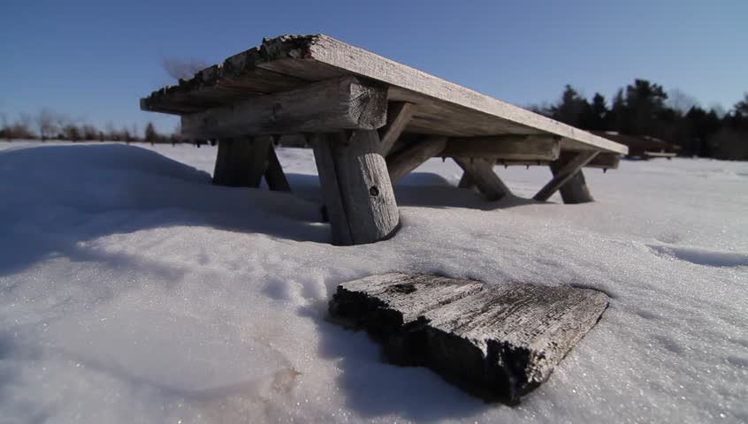 Picnic table half-buried in snow, bench barely protruding