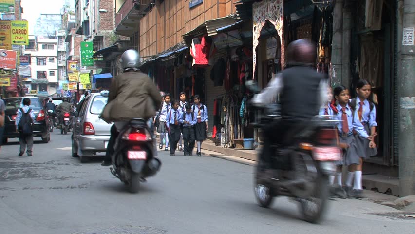 KATHMANDU - CIRCA 2010: People, cars and bikes circulate through the city circa 2010 in Kathmandu.