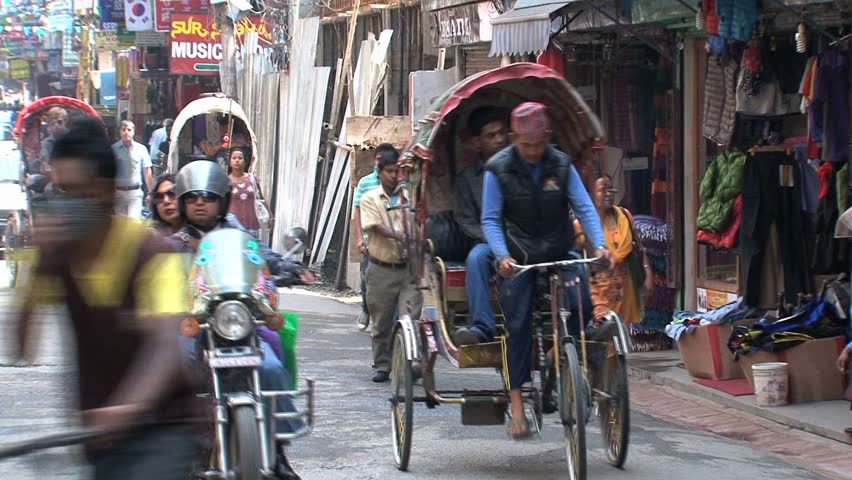 KATHMANDU - CIRCA 2010: People, cars and bikes circulate through the city circa 2010 in Kathmandu.