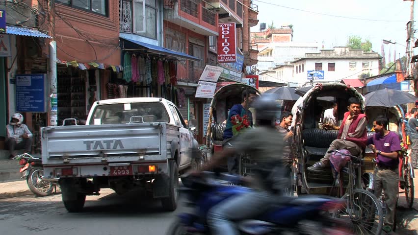 KATHMANDU - CIRCA 2010: People, cars and bikes circulate through the city circa 2010 in Kathmandu.
