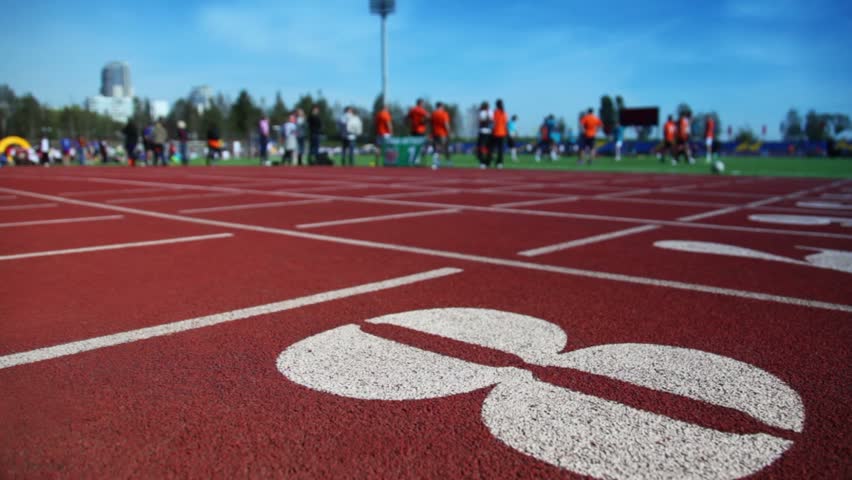 Running track number eight closeup, other treadmills with special red cover for racing, people walk around