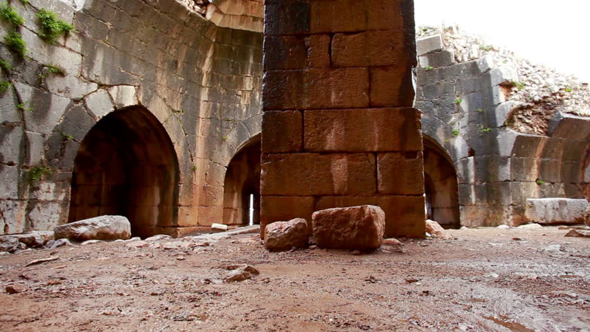 Dolly slider move up and away from a massive pillar and archways inside the "Beautiful" tower of the Nimrod Fortress in the Golan Heights region of Israel.