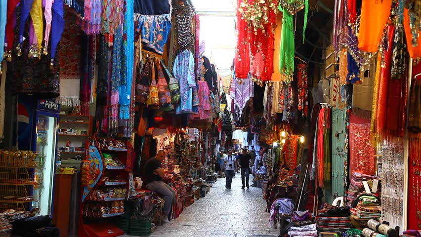 JERUSALEM, ISRAEL - CIRCA OCT 2011: Tourists look for souvenirs in a colorful alley of a bazaar market circa October 2011 in Jerusalem.