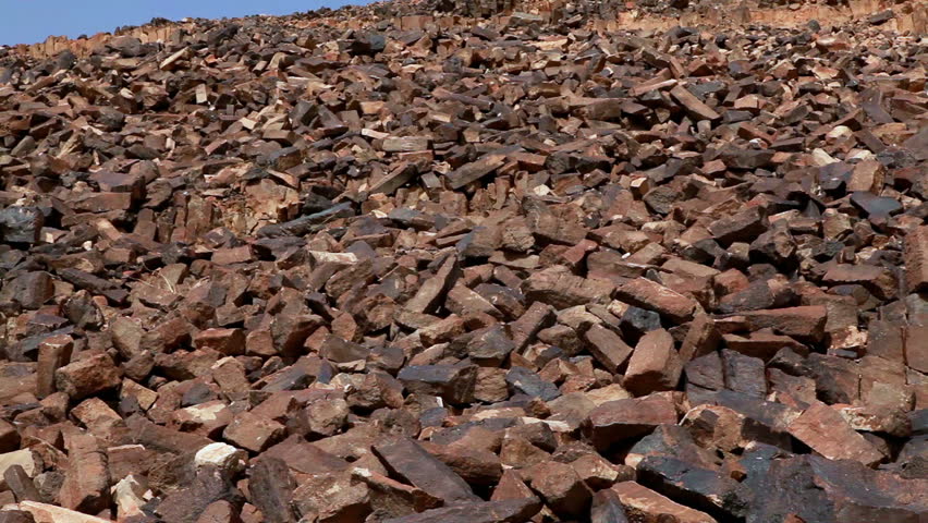 Low angled tilt-up of the rocky hillside to blue sky at Ha-Minsara (The Carpentry Shop), a geological formation in the Mitzpe Ramon Crater in Israel. 