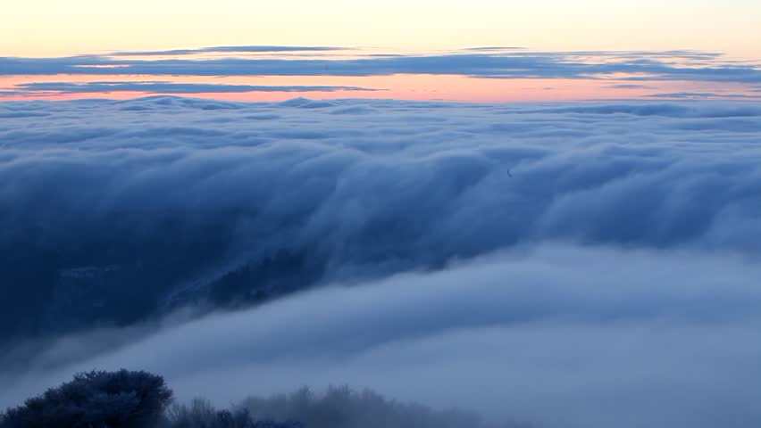Moving winter postcard: Snowy hills. Dramatic clouds form in a valley