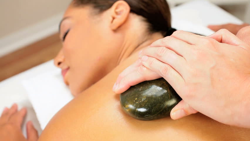 Female Spa Client Receiving Hot Stone Therapy