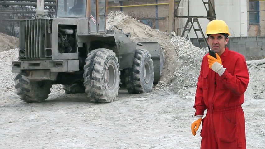 Worker supervising the work of the bulldozer in the factory. HD 1080i.