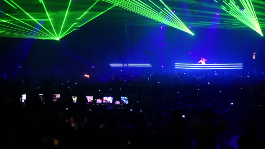 MOSCOW - MAY 6: Green lasers rays above crowd, popular dutch DJ Armin Van Buuren on stage in blue light on May 6, 2011 in Moscow, Russia.