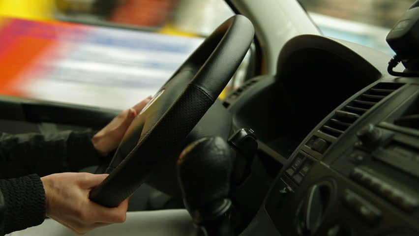 Woman driving in the city, the focus  on the steering wheel and hand