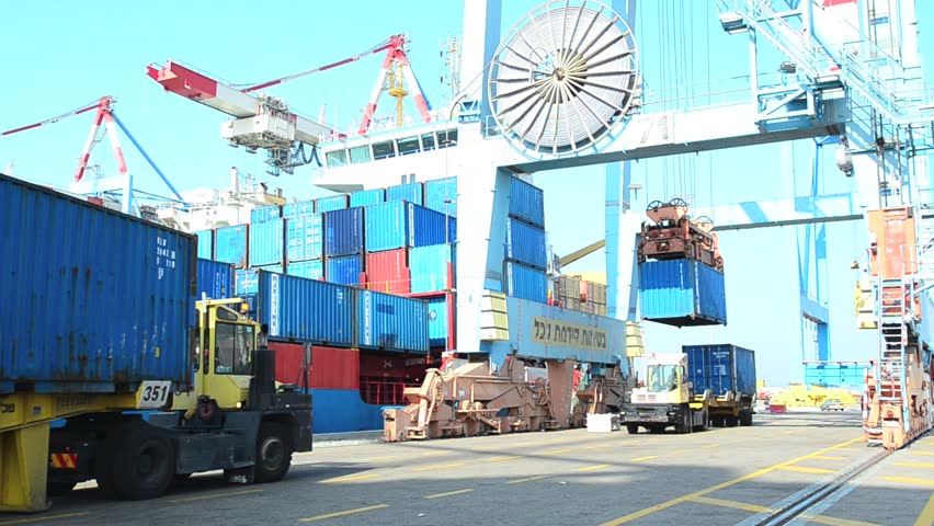 ASHDOD ISRAEL - DECEMBER 19: A cargo ship is loaded and unloaded by container crane in Ashdod seaport, Israel on December 19 2011.