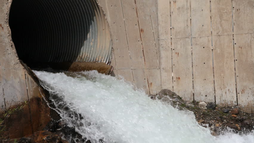 Storm or flood outlet with rushing water. Helps prevent flood damage by diverting water flow.