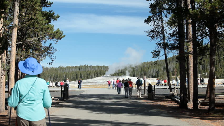 Spectators visit Old Faithful Geyser Yellowstone National Park, Wyoming. Most famous geyser in the world.
