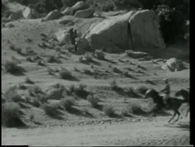 Wide shot cowboys on a wild chase on mountain range