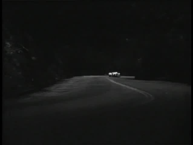 Motorcycle police chasing sports car on country road