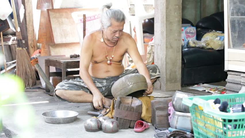 BANGKOK - NOVEMBER 12: A man shapes an alms bowl in Bangkok, Thailand on November 12, 2011. Alms bowls are used by monks during their morning processions.