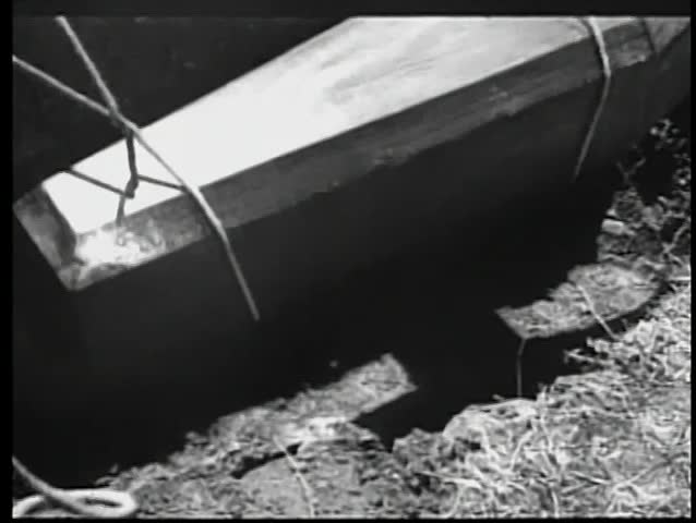 Coffin lowered on ropes into pit