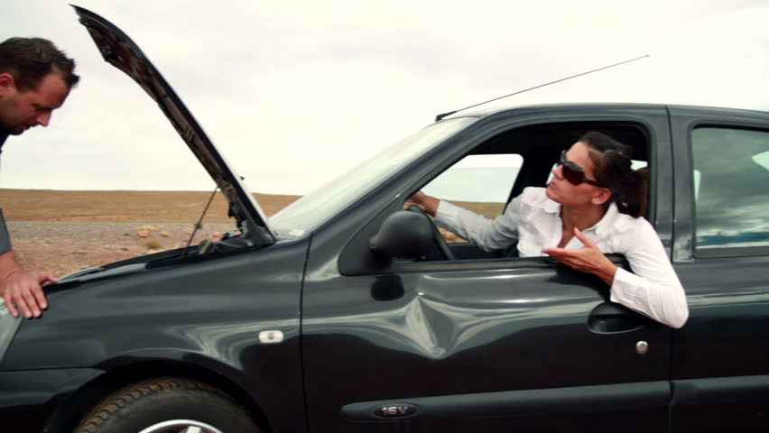 Business couple having fight by the broken car