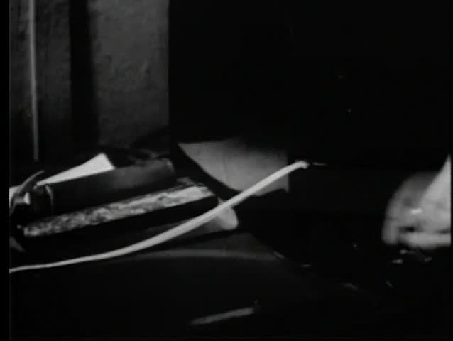 Close-up of hand tearing teletype tape out of machine