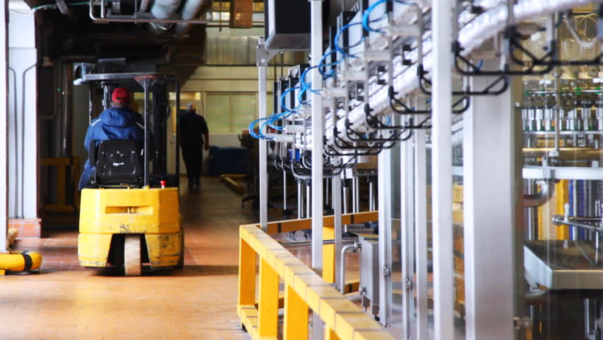 small forklift goes near conveyor inside dairy factory