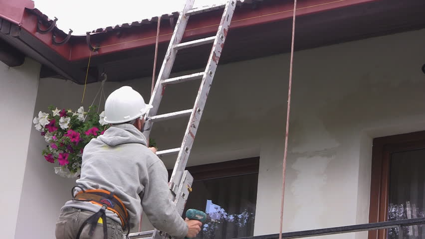 Construction worker climbs ladder