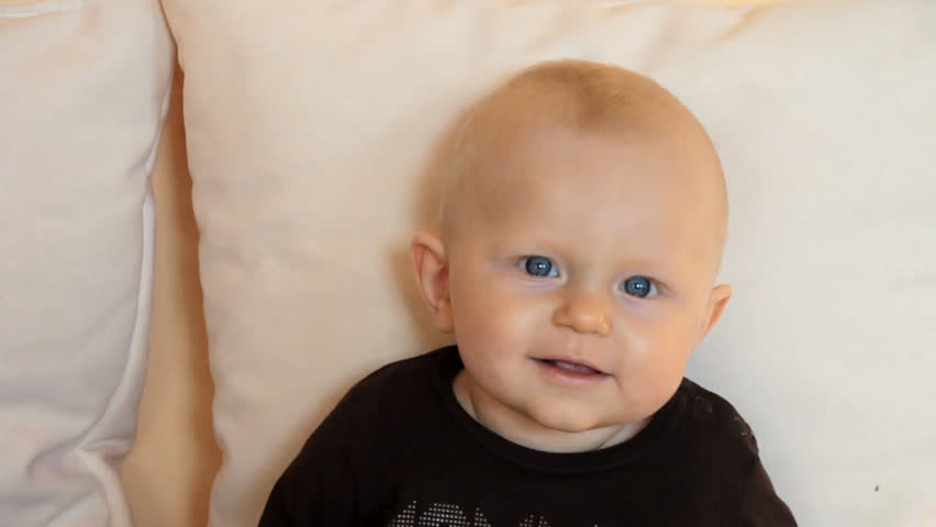 6 months boy smiling and looks interested