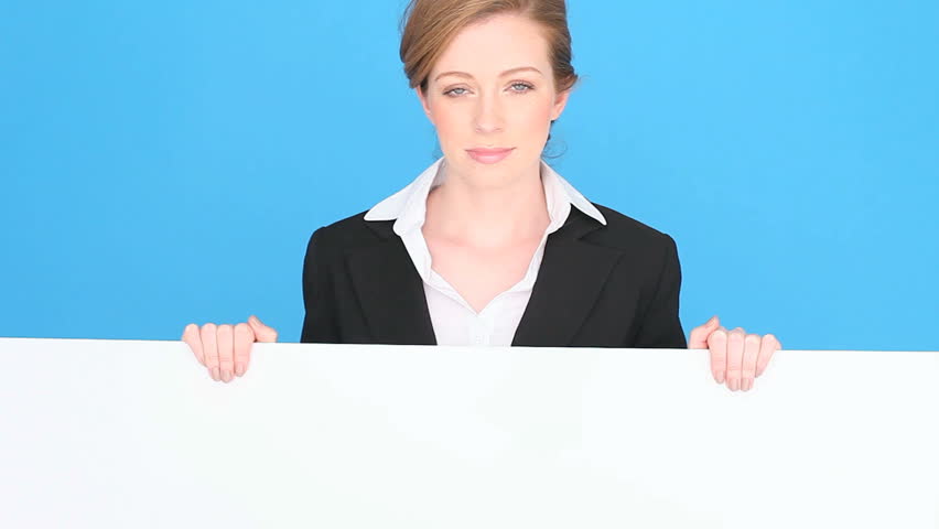 Smiling professional or businesswoman holding a large blank white sign, blue studio background
