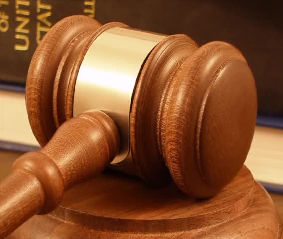 Gavel resting on block.  Law books in background.