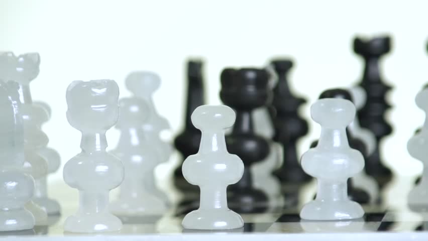 Male hand moving glass chess pieces on board