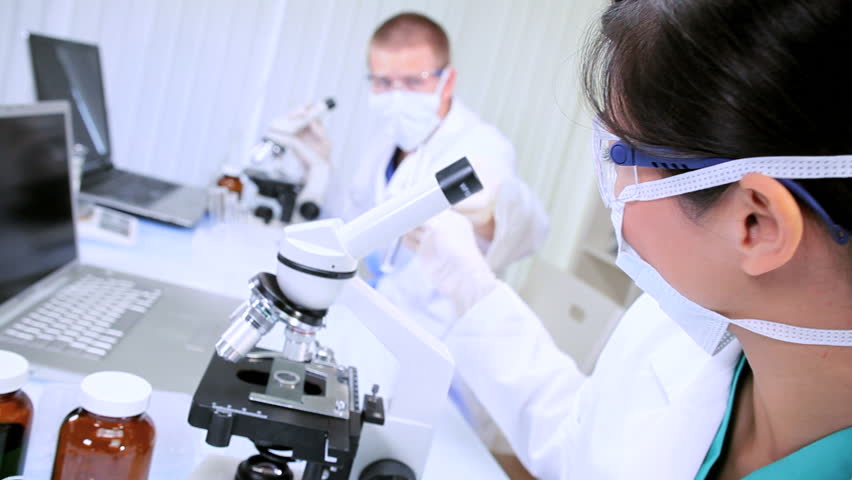 Medical researchers examining test tube specimens in sterile laboratory conditions